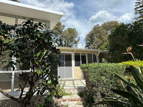 A house with a white exterior and a garden in front.