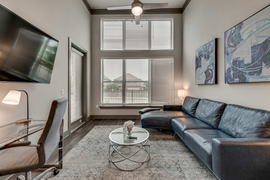 a living room with leather furniture and a large window