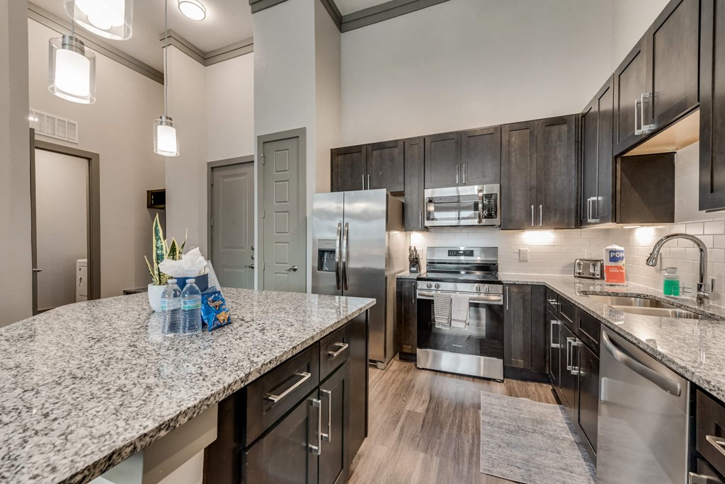 a kitchen with granite counter tops and stainless steel appliances