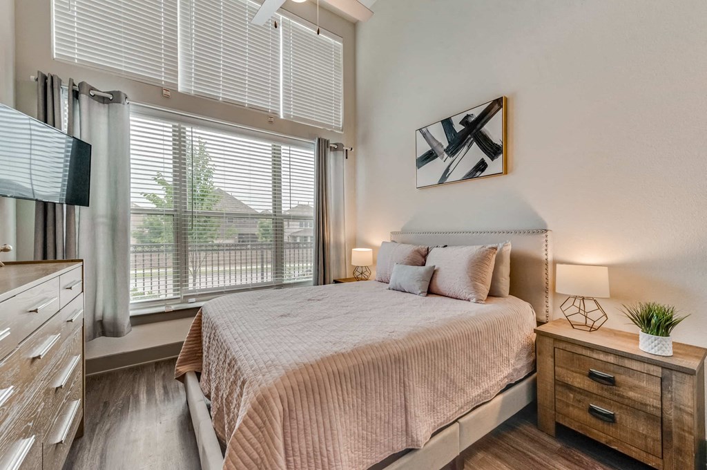 a bedroom with a bed and a large window