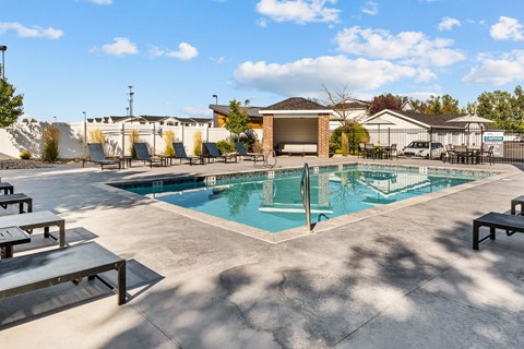 Swimming Pool with lounge seating surrounding perimeter at Eagles Landing, Ammon, Idaho