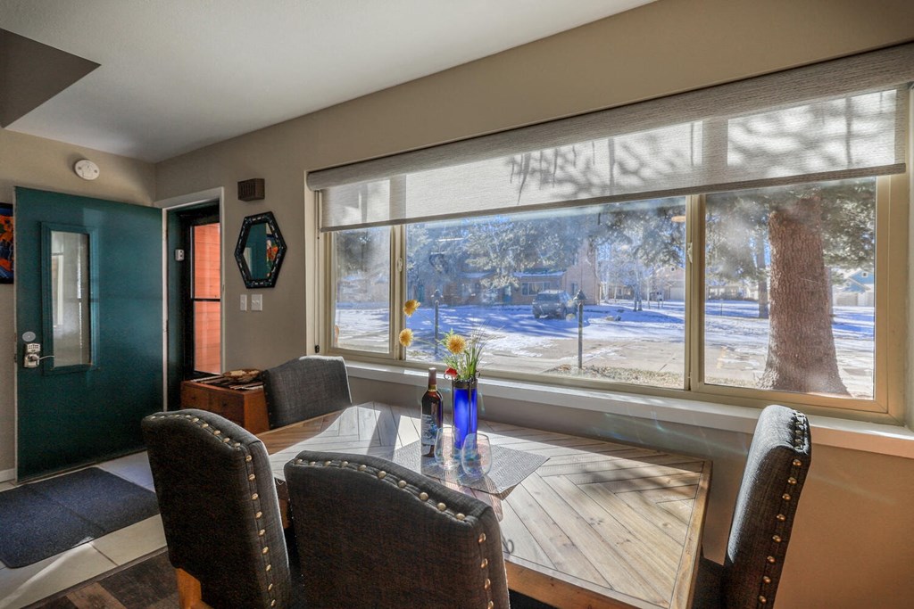 a dining room with a large window and a table with chairs