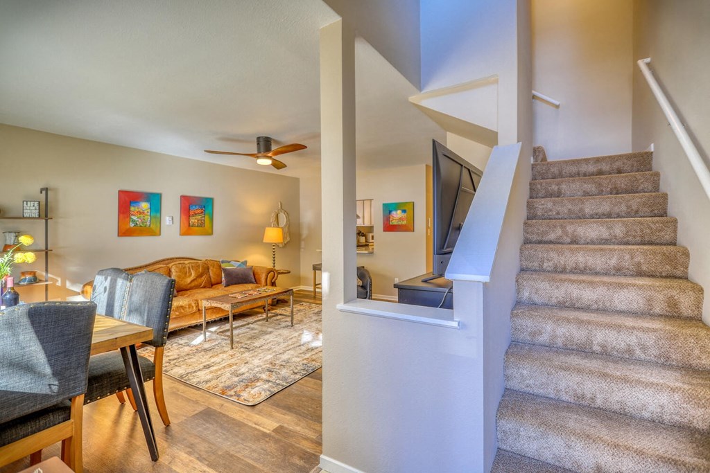 a living room with a staircase leading up to it