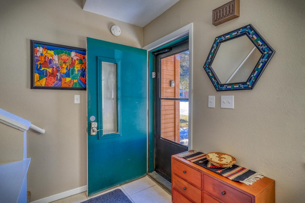 a entryway with a blue door and a wooden dresser