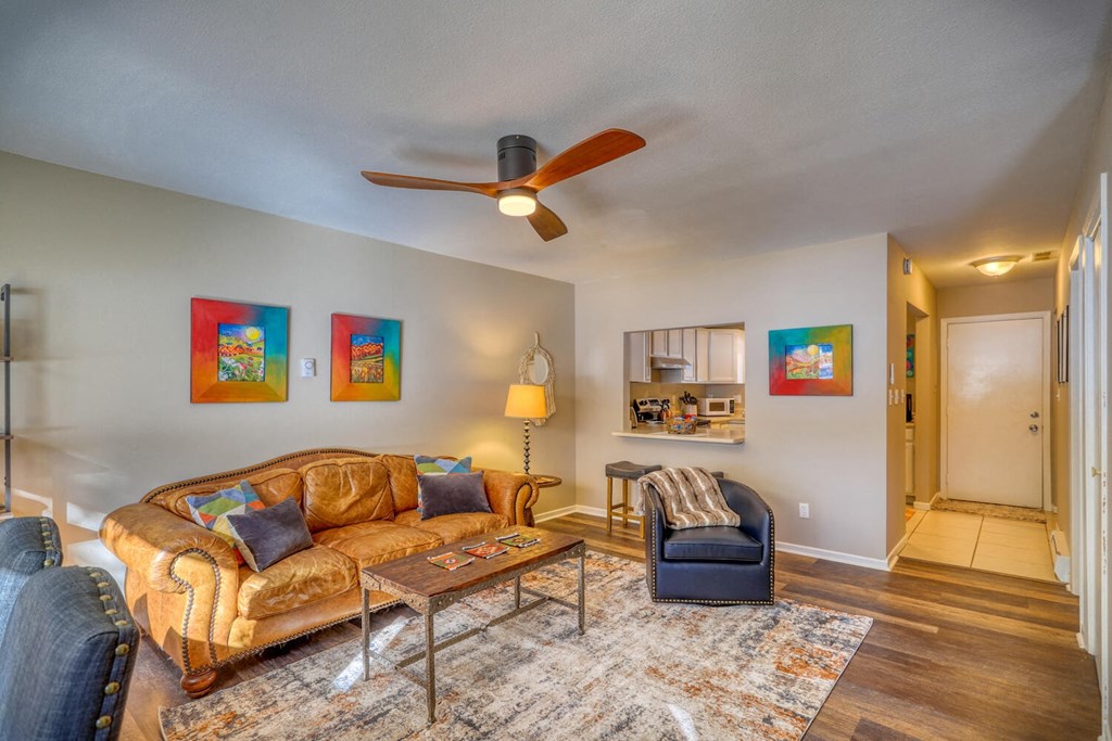 a living room with a couch and chair and a ceiling fan