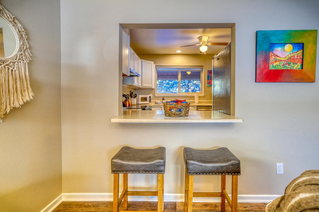 two stools in front of a kitchen bar with a mirror