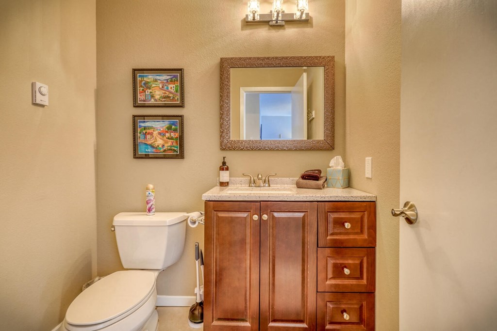 a bathroom with a toilet and a sink and a mirror