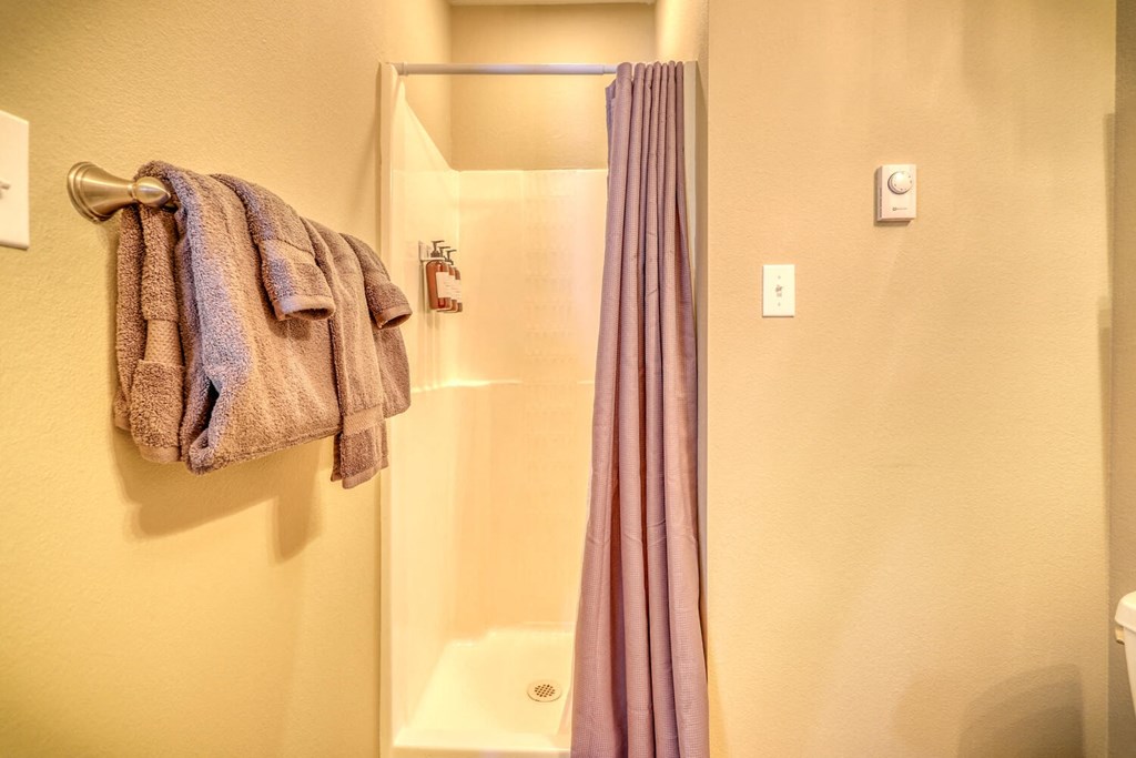 a bathroom with a shower and towels on a towel rack