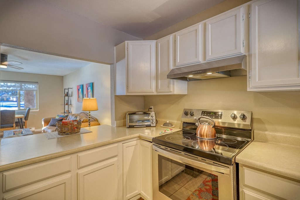 a kitchen with white cabinets and a stove top oven