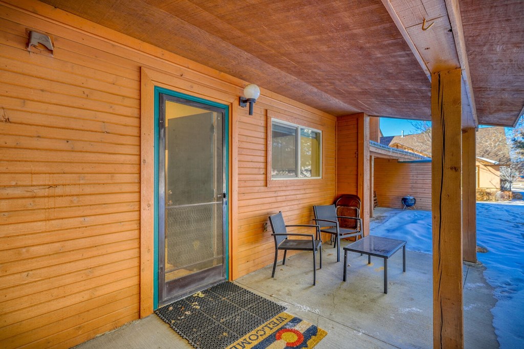 a patio with two chairs and a glass door