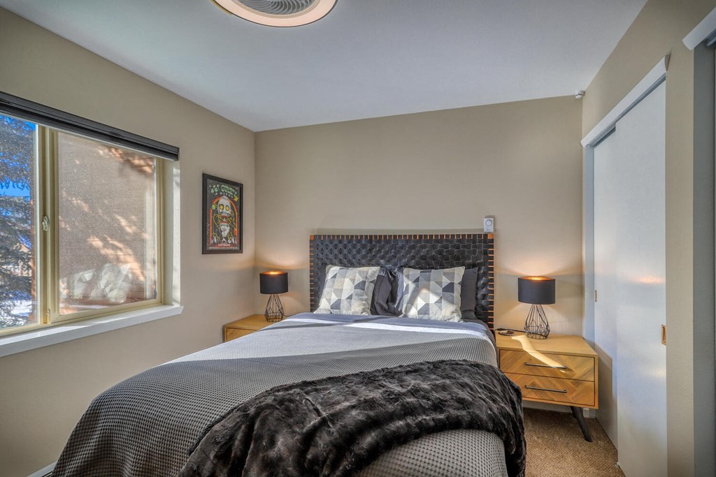 a bedroom with a bed and two windows