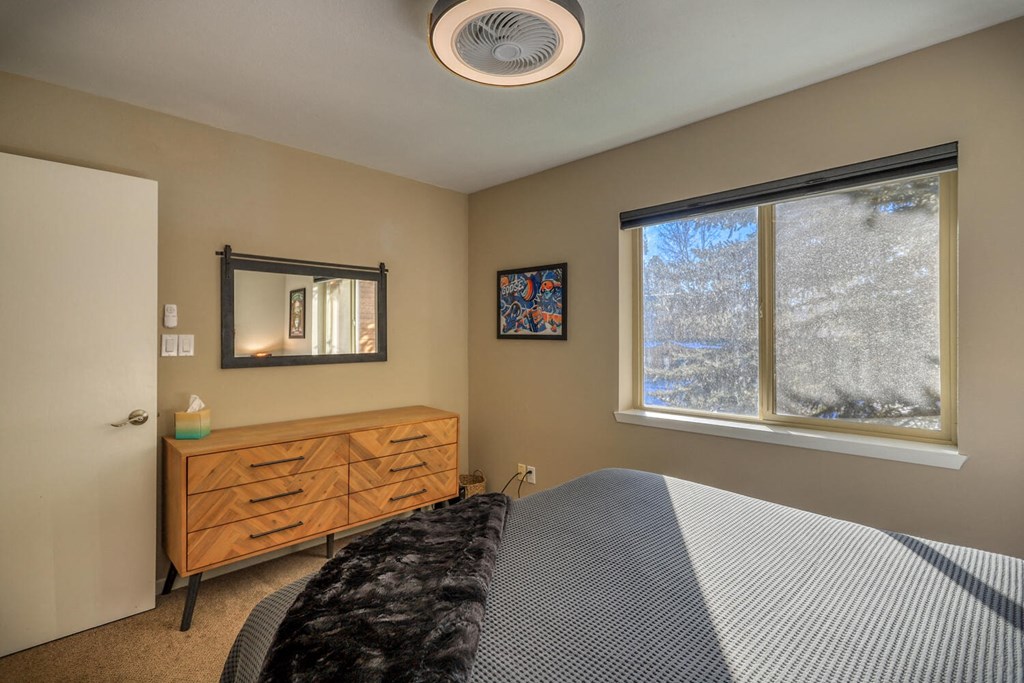 a bedroom with a bed and a large window