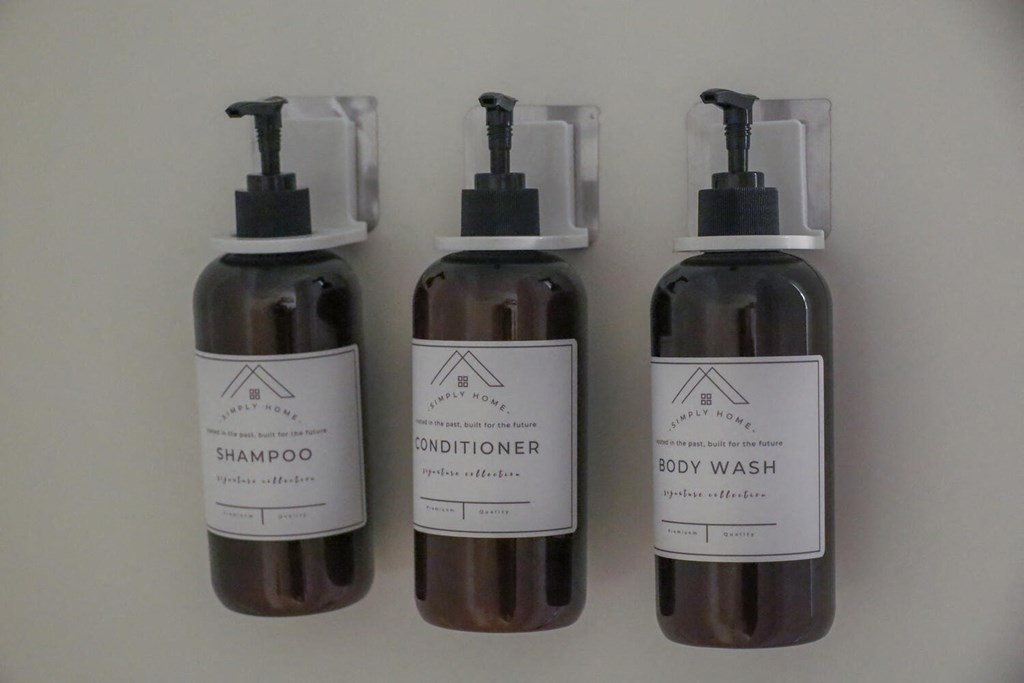 three bottles of grooming products on a white background