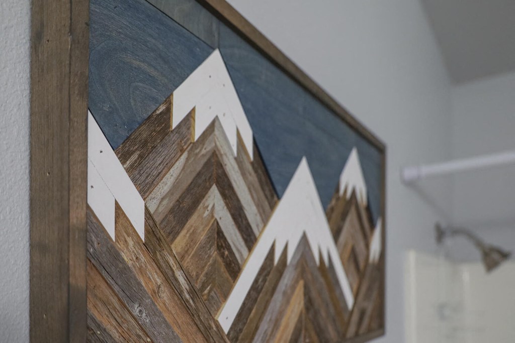 a painting of a mountain range on a wooden wall