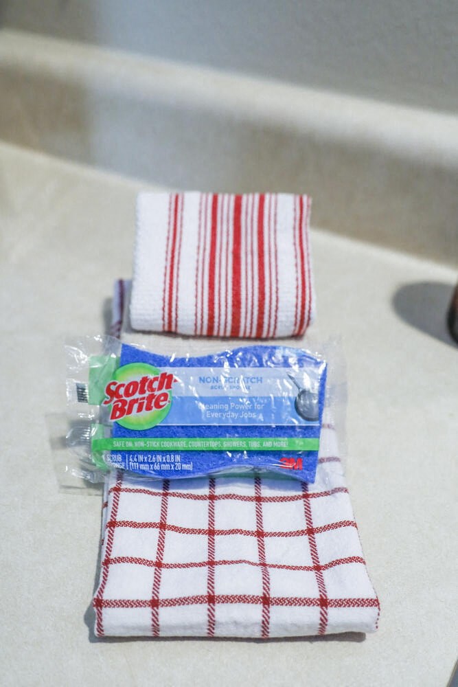 a package of toothbrushes and a roll of toothpaste sitting on a towel