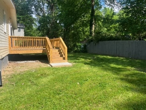 a backyard with a wooden deck and a fence
