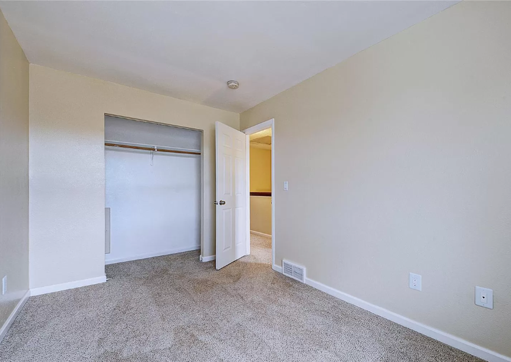 a bedroom with a closet and a door to a bathroom