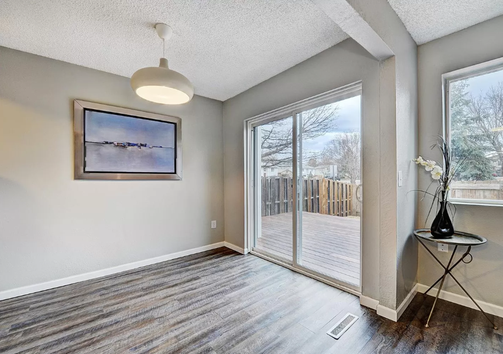 an empty living room with a sliding glass door to a deck