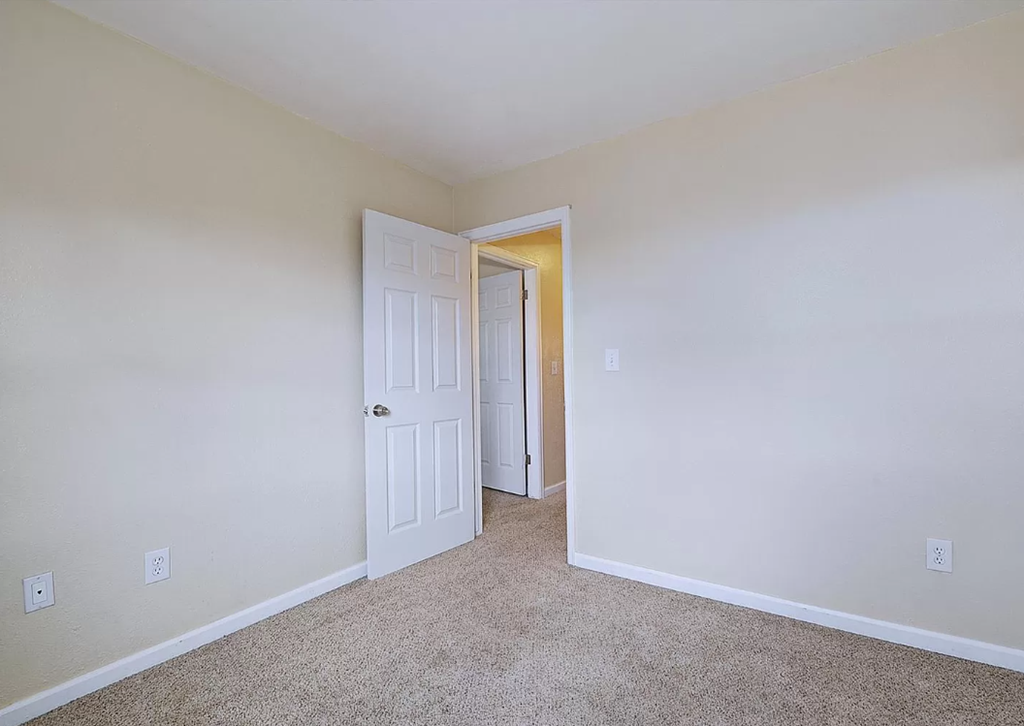 a bedroom with a white door and a closet