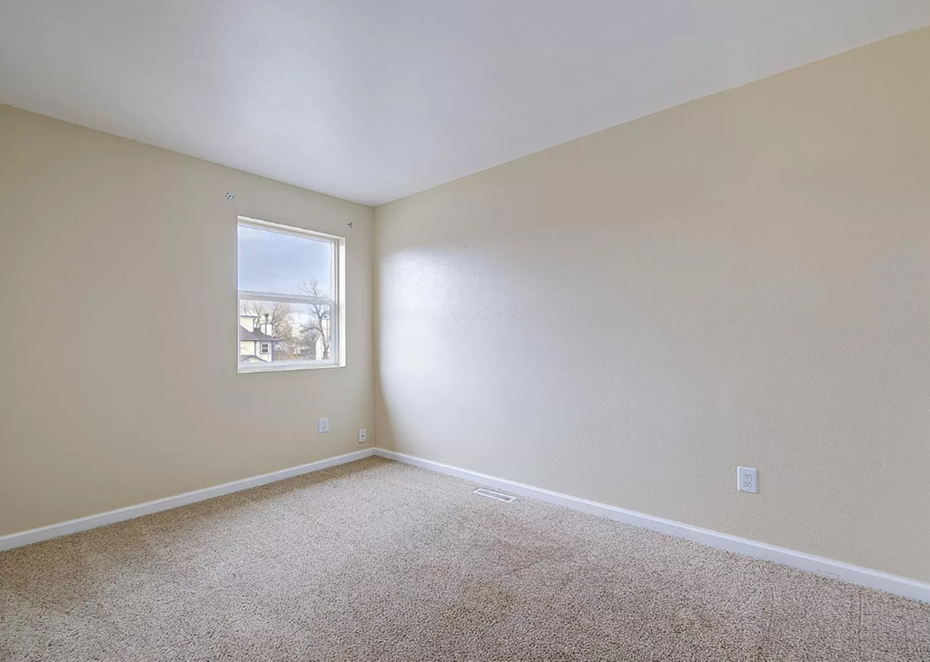 an empty room with carpet and a window