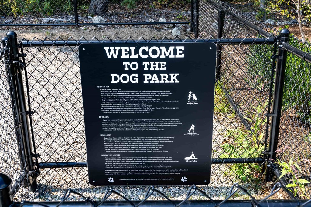 a sign on a fence saying welcome to the dog park