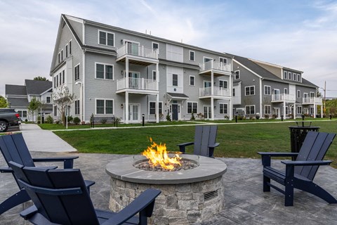 an outdoor fire pit in front of an apartment building