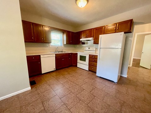 an empty kitchen with a refrigerator and a sink