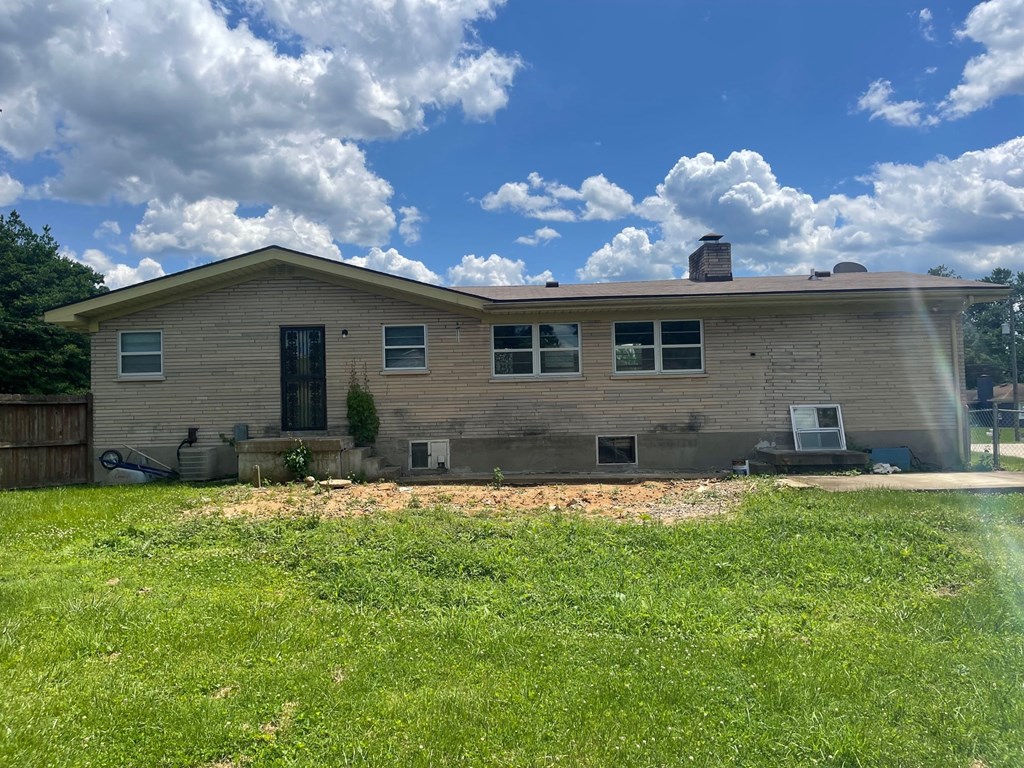 a house with a yard and a blue sky with clouds
