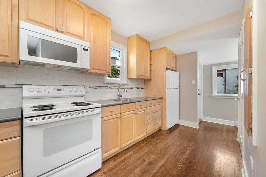 a kitchen with white appliances and wooden cabinets