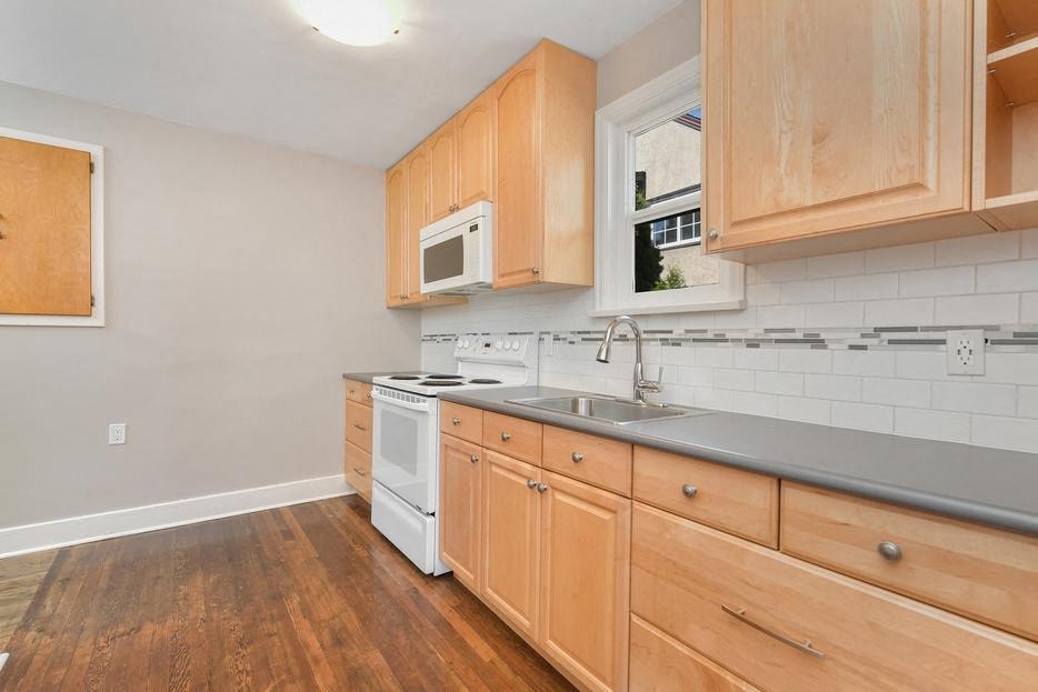 a kitchen with wooden cabinets and a stove and a sink