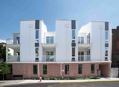 a rendering of a three story apartment building with balconies and a fire hydrant