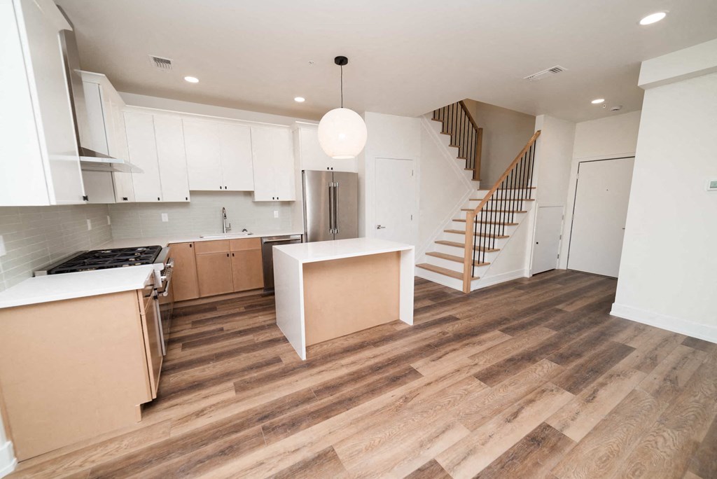 a renovated kitchen with white cabinets and a stainless steel refrigerator