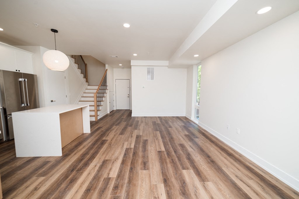 a living room with white walls and a wooden floor