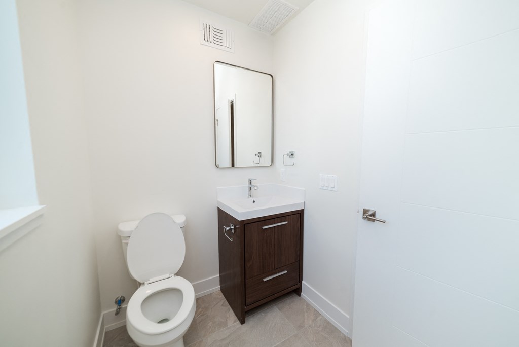 a bathroom with a toilet and a sink and a mirror