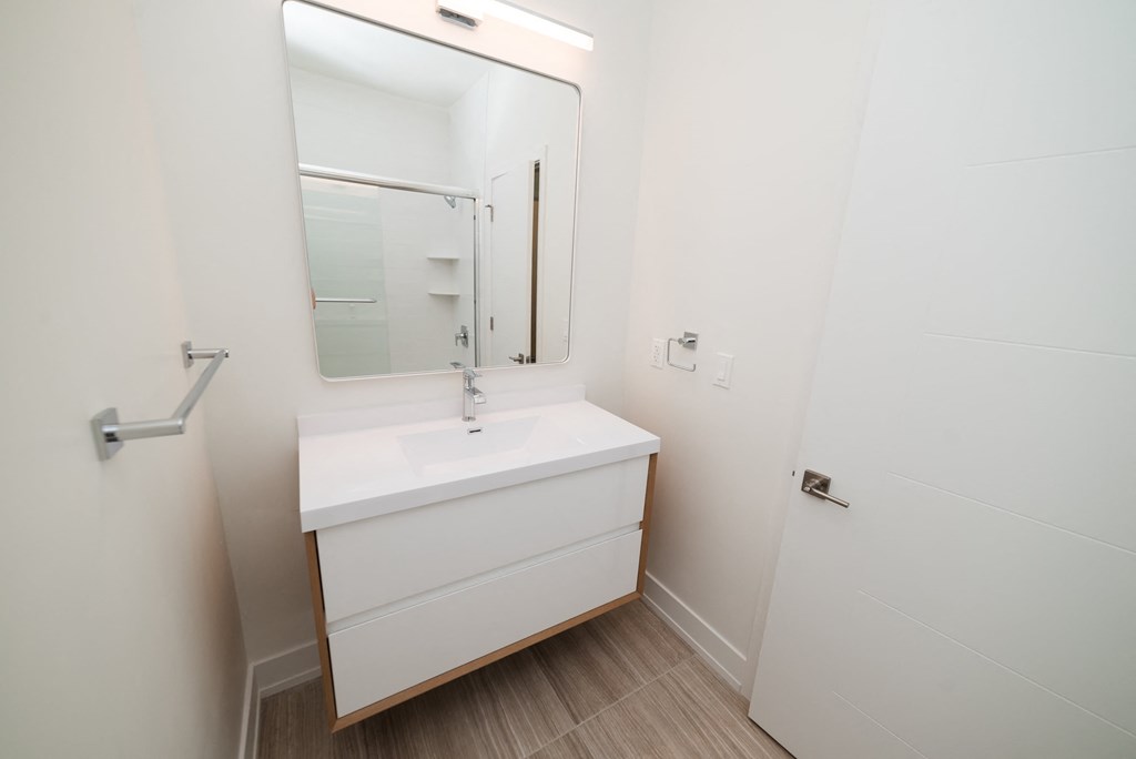 a white bathroom with a sink and a mirror