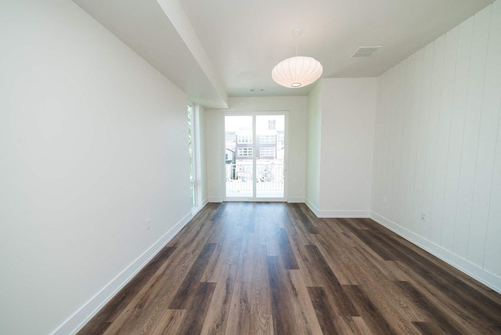 a living room with white walls and wood floors