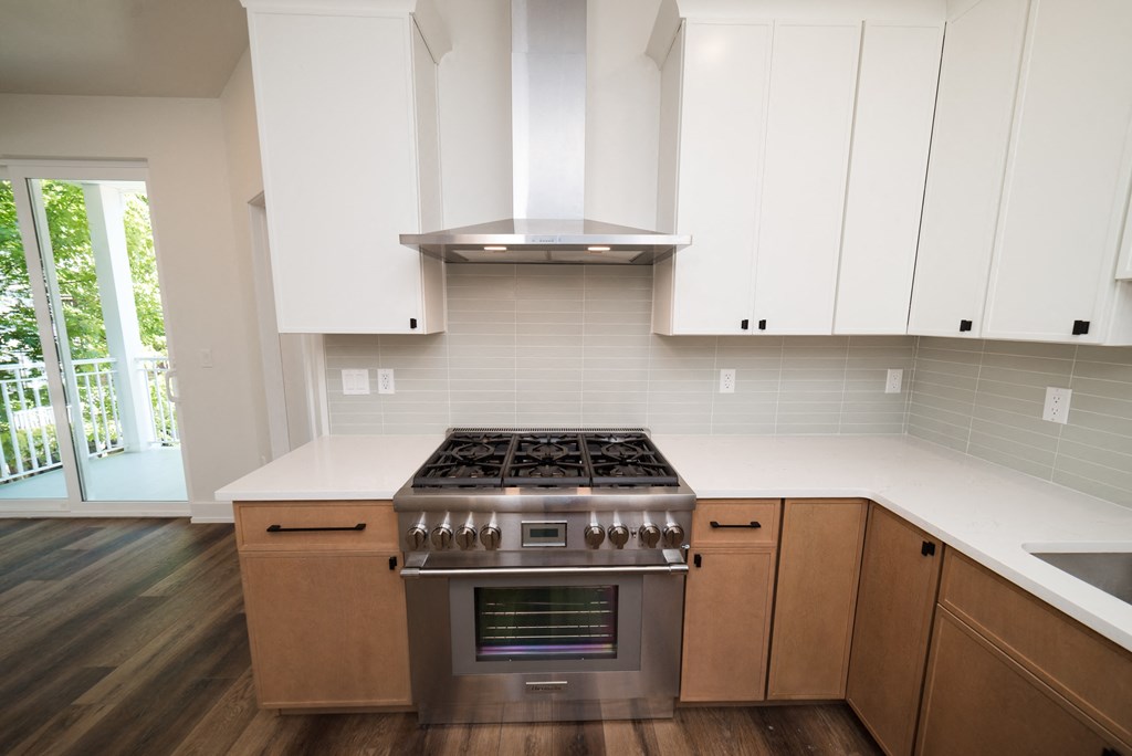 a kitchen with white cabinets and a stainless steel stove