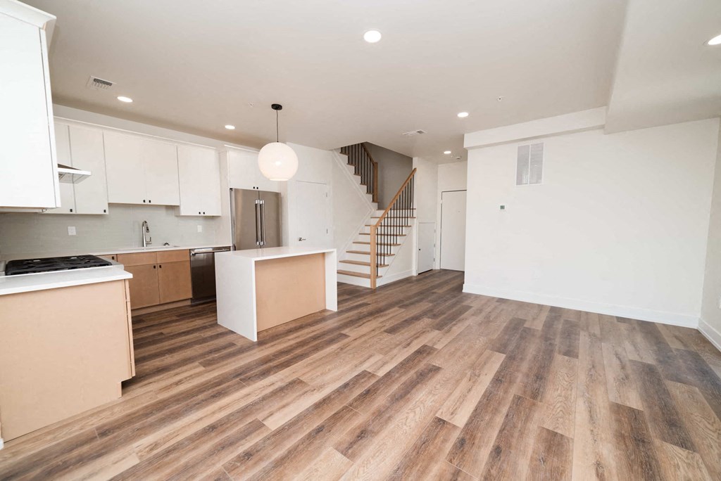 a living room with a kitchen and a staircase