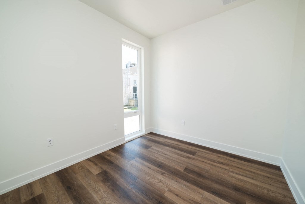 a living room with white walls and wood floors
