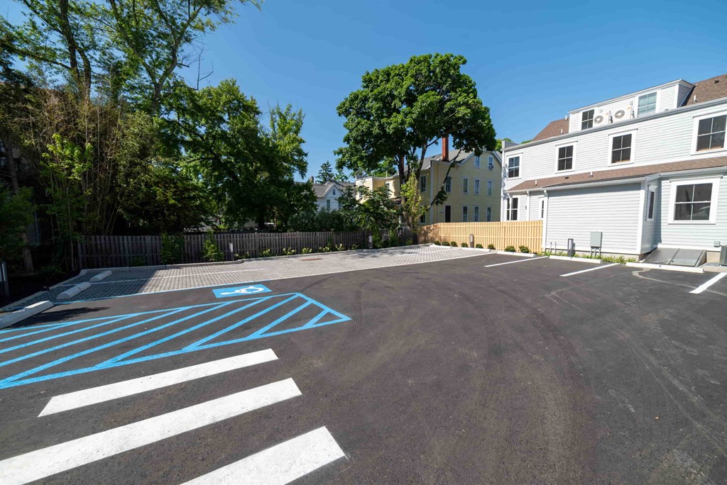 a parking lot with a house and a zebra crossing