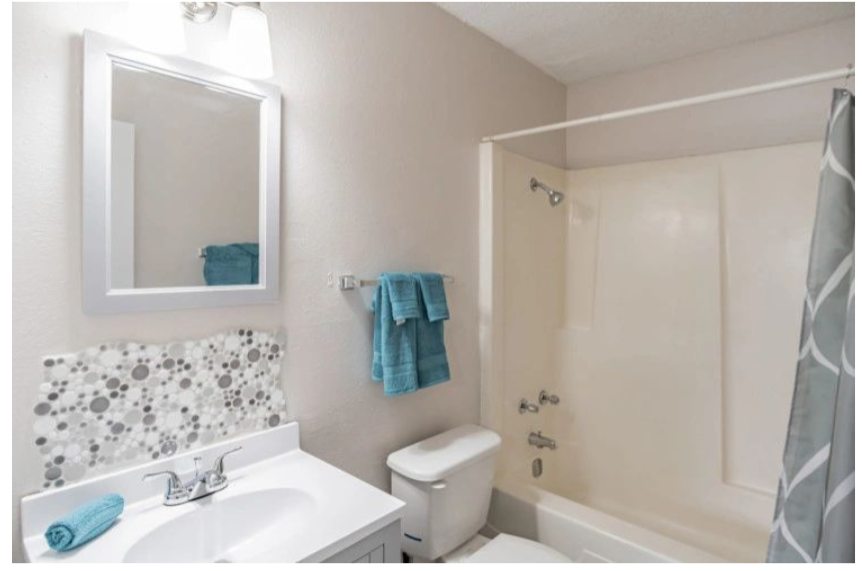 a bathroom with a sink toilet and a mirror