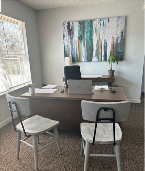 a home office with two chairs and a desk with a laptop