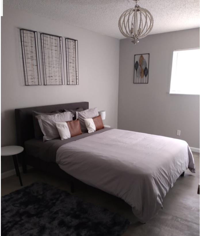 a bedroom with a bed and a chandelier