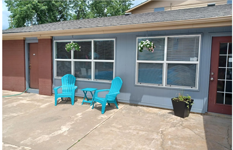 two blue chairs in front of a house