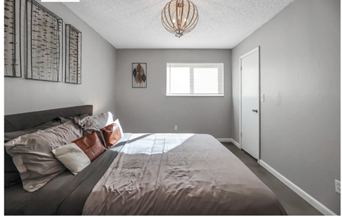 a bedroom with a large bed and a chandelier