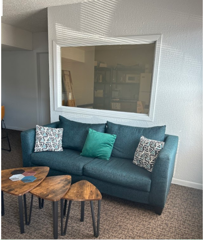 a living room with a blue couch and two tables