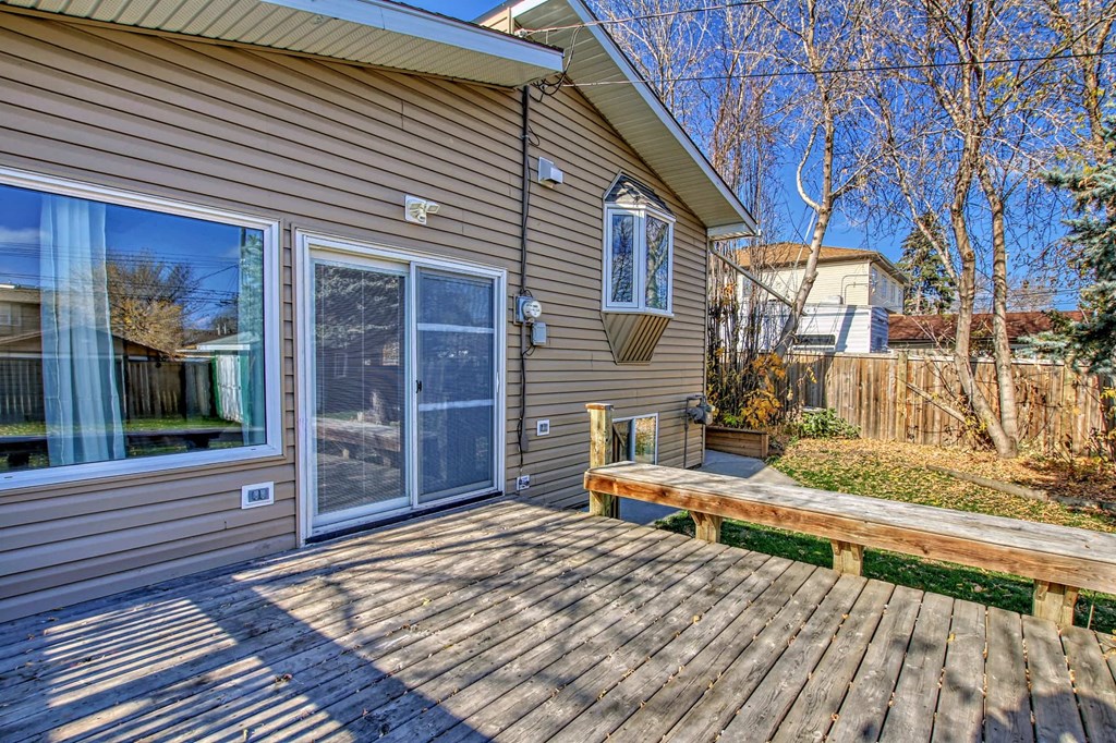 a back deck with a bench and a sliding glass door