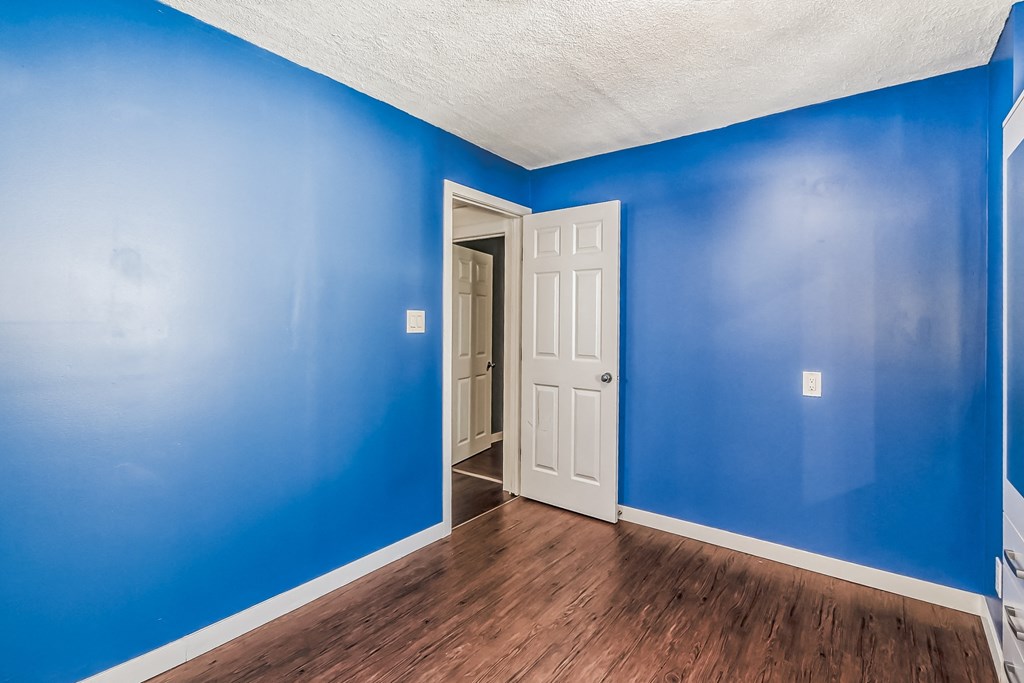 an empty room with blue walls and a white door