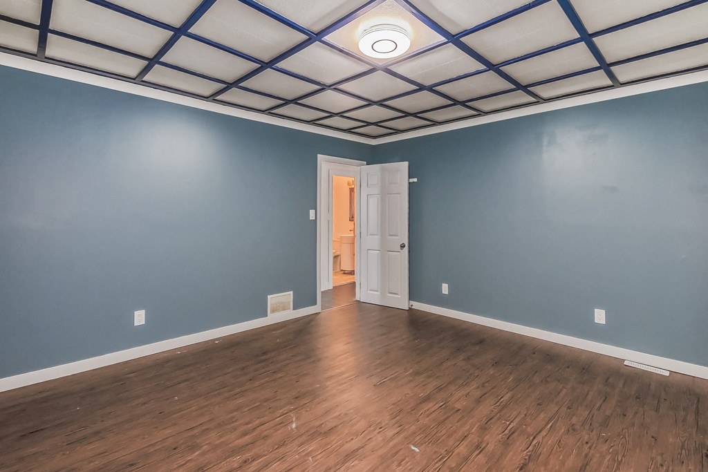 an empty room with blue walls and a wooden floor and a white door