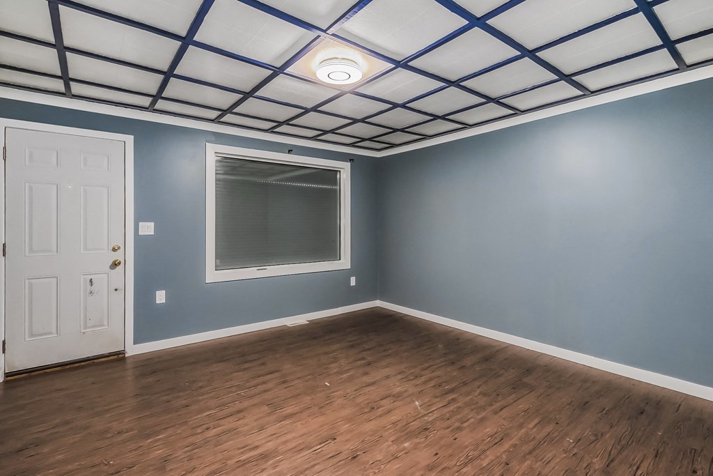 an empty room with blue walls and a window